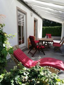 基姆湖畔普林Ferienhaus Deller的庭院配有红色的椅子、桌子和桌椅