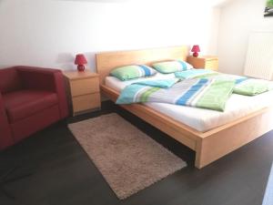 基姆湖畔普林Ferienhaus Deller的一间卧室配有一张床和一张红色椅子