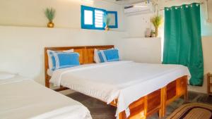 杜蒂戈林Aqua Outback的一间卧室配有两张带蓝白色枕头的床