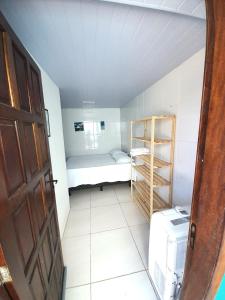 卡波布里奥Suítes Brisa Tropical的小房间设有小床和架子
