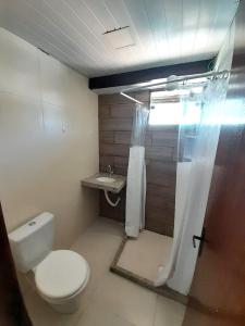 卡波布里奥Suítes Brisa Tropical的一间带卫生间和淋浴帘的浴室