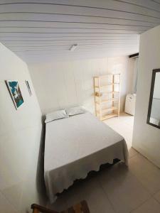 卡波布里奥Suítes Brisa Tropical的一间白色客房内的床铺卧室