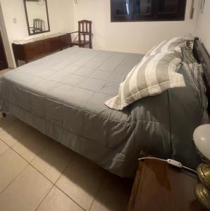 圣地亚哥-德尔埃斯特罗Casa Céntrica totalmente equipada !!!的一张带灰色棉被的床