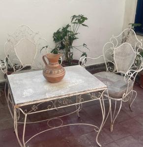 圣地亚哥-德尔埃斯特罗Casa Céntrica totalmente equipada !!!的一张带两把椅子的桌子上的花瓶