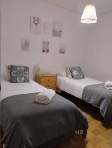 洛格罗尼奥Apartamento a 10 minutos de la Calle Laurel的一间卧室设有两张床和一盏灯,墙上挂着图片