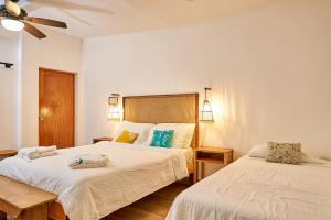 拉斯彭尼塔斯Aaki Hotel的一间卧室配有两张床和吊扇