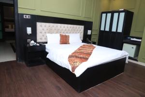伊斯兰堡Winter Hotel的一间卧室配有一张大床和大床头板