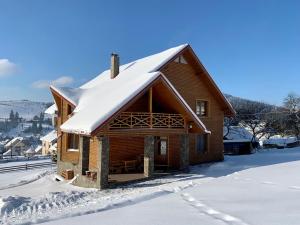 布克维Guest House Velet的小木屋,设有雪盖屋顶