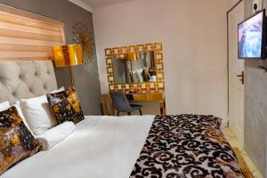 比勒陀利亚Homes of Ace Gold的配有一张床和一张书桌的酒店客房
