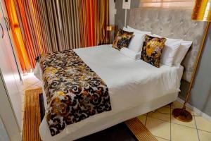 比勒陀利亚Homes of Ace Gold的卧室配有一张带白色床单和枕头的大床。