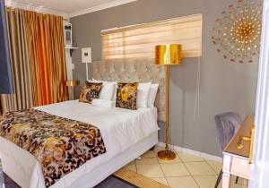 比勒陀利亚Homes of Ace Gold的一间卧室配有一张大床和一盏灯