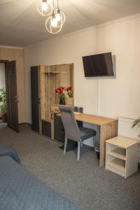 BushtynoГотельно-ресторанний комплекс Фамілія的客房设有书桌和墙上的电视