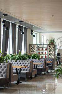 BushtynoГотельно-ресторанний комплекс Фамілія的用餐室配有桌椅和植物