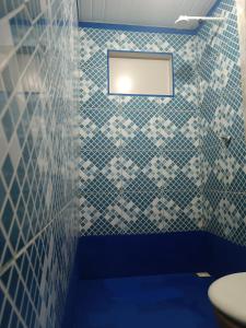 萨利诺波利斯Kitnet no Farol Velho的浴室拥有蓝色和白色的瓷砖墙壁,设有卫生间