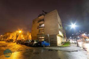 贝拉内Apartments Ivangrad的一座有汽车在晚上停在停车场的建筑