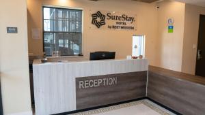 休斯顿SureStay Hotel by Best Western Houston Southeast的医院大厅的前台,配有笔记本电脑