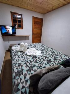 坎波斯杜若尔当Pousada Lofts e Suítes Campos的卧室配有一张床铺,墙上配有电视