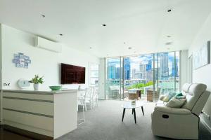 奥克兰Waterfront Apartment with Sky tower & Harbour View的厨房以及带沙发和桌子的客厅。
