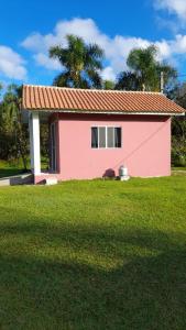 巴拉那州蓬塔尔Mini Casa Chácara Zulin's - AMOR E ACONCHEGO的一座带草地庭院的粉红色小房子