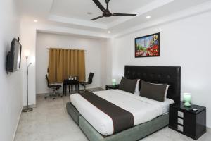 新德里Collection O Hotel Residency Near Dwarka Sector 21 Metro Station的一间卧室配有一张大床和一张桌椅