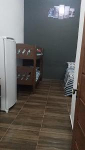 卡纳内亚Cantinho do Sossego - kitnets的客房设有冰箱和瓷砖地板。