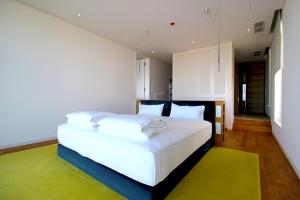 都拉斯Deluxe Villa Jante Infinity Pool的一间卧室配有一张带白色床单的大床