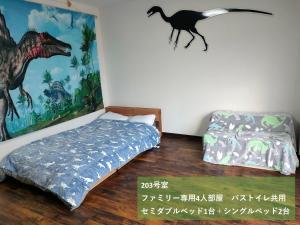 胜山市11月フルリフォーム 12月オープン恐竜一色ゲストハウスDinosaur Guesthouse的卧室配有壁挂式恐龙壁画和1张床