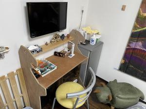 胜山市11月フルリフォーム 12月オープン恐竜一色ゲストハウスDinosaur Guesthouse的小房间设有一张桌子、一台电视和一张桌子