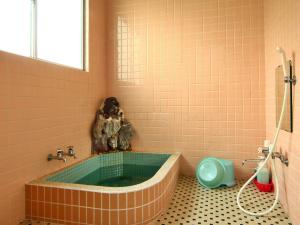 Chikuniロッヂ秀岳的带浴缸的浴室,铺有瓷砖地板