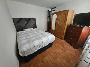 阿雷基帕Casa familiar en Arequipa的一间卧室配有一张床、梳妆台和电视。