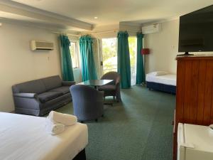 瓦布利尔Seaside Garden Retreat Accommodation的酒店客房配有床、沙发和桌子。