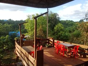 邦隆Farmer home stay & trekking的木制甲板配有红色椅子和桌子