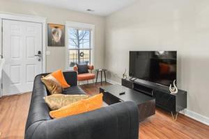 底特律Affordable 1-BR by DMC Detroit的客厅配有黑色沙发和平面电视。