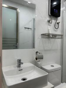 ValenciaKekehyu Business Hotel的白色的浴室设有水槽和卫生间。