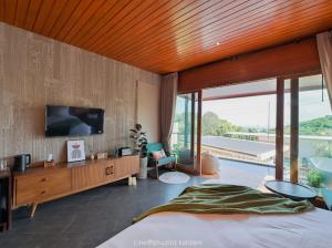 格兰岛Phuzita Kohlarn-ภูศิตา เกาะล้าน的一间卧室配有一张床,墙上配有电视