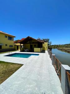 卡波布里奥Ótima Casa com Piscina, Sauna e Churrasqueira的河畔带游泳池的房子