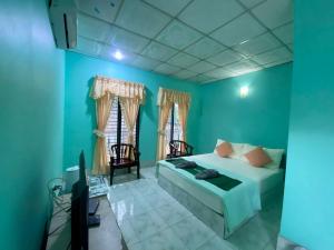 Ban Samnak PlingThungtako Resort的一间卧室设有蓝色的墙壁、一张床和电视。