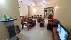 米瑞莎Nirmali Resort的带电视的客厅和带椅子的客厅。