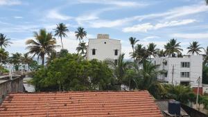 米瑞莎Nirmali Resort的一座白色的建筑,前面有棕榈树