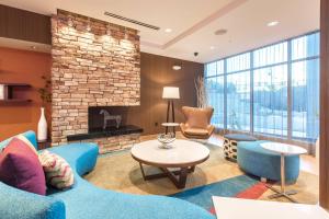 阿什维尔Fairfield Inn & Suites by Marriott Asheville Tunnel Road的客厅配有蓝色的家具和壁炉