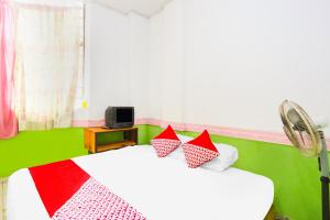 JodohOYO 91344 Wr House Syariah Batam的一间卧室配有两张带红白色枕头的床
