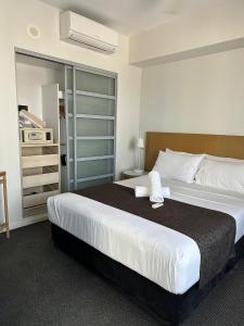 达尔文Pandanas Apt 5 15th fl Darwin CBD Harbor views的一间卧室配有一张大床和一个衣柜