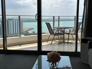 达尔文Pandanas Apt 5 15th fl Darwin CBD Harbor views的阳台配有桌椅,享有海景。