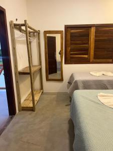 圣阿马鲁Pacas Suítes Casa & Chalés的一间设有两张床和镜子的房间