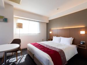 东京门前仲町东急酒店的酒店客房设有一张大床和一张桌子。