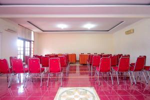 TimuranSuper OYO 759 Hotel Dewi Sri的一间房间,房间内设有红色的椅子和桌子