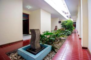 TimuranSuper OYO 759 Hotel Dewi Sri的建筑中间带雕像的走廊