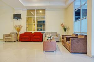 马卡萨Collection O 91414 Hotel Marina Beach的带沙发和椅子的客厅以及电视