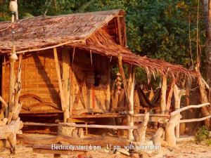 俊穆岛Simple Life Bungalows的小木屋设有茅草屋顶和门廊