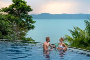 普吉镇The Westin Siray Bay Resort & Spa, Phuket的坐在游泳池里的男人和女人
